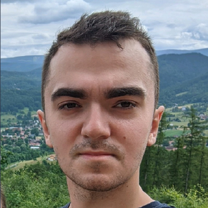 Portret Adama Bednarka na tle górskiego krajobrazu.